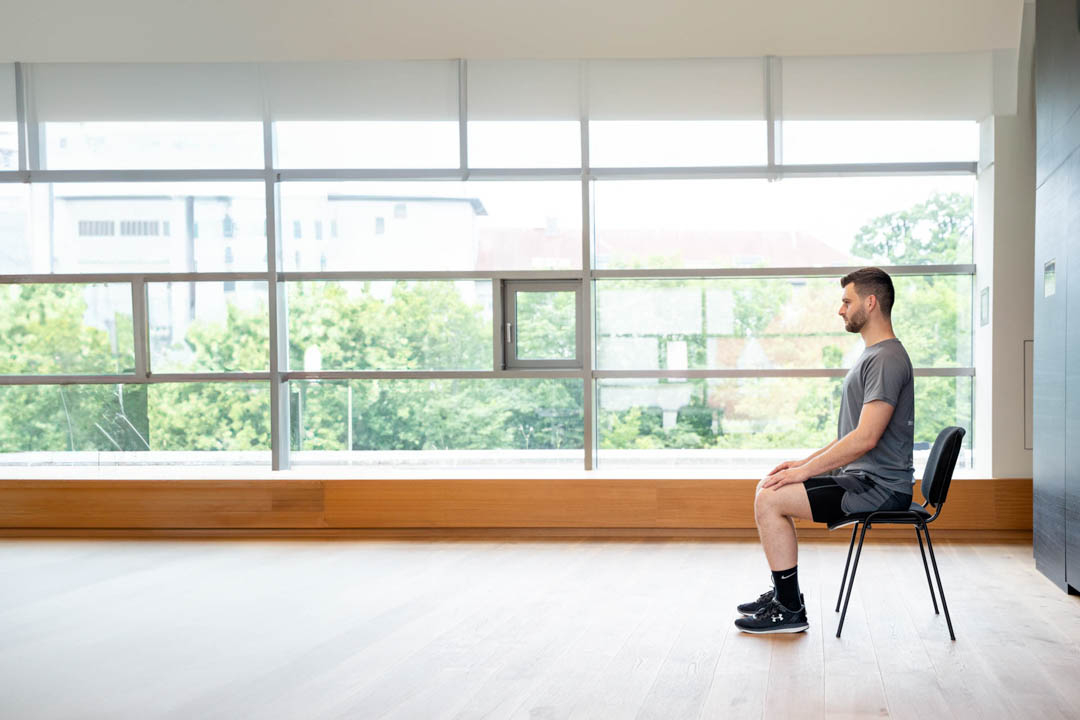 Mann der auf einem Stuhl sitzt