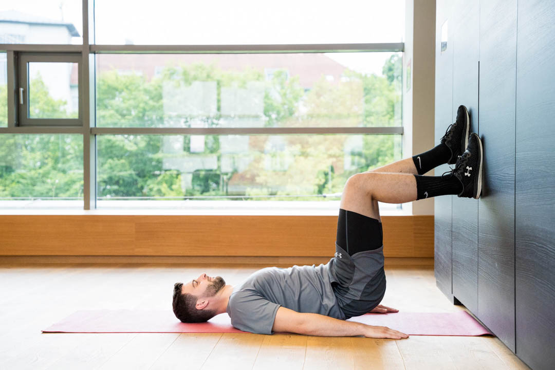 Mann der die Übung Wandläufer macht