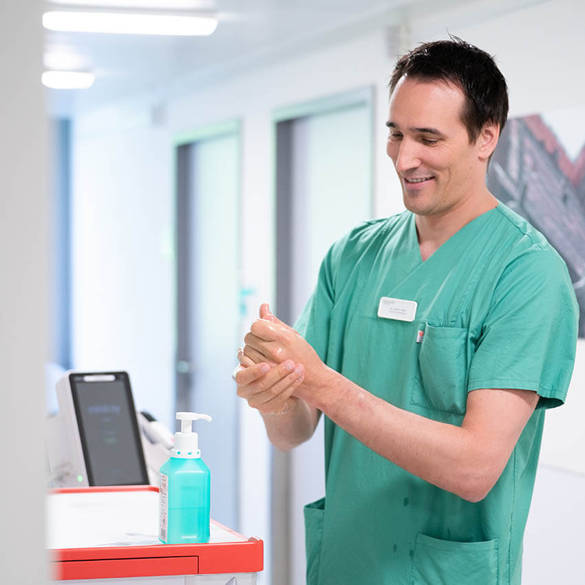 Dr. Keller desinfiziert sich die Hände