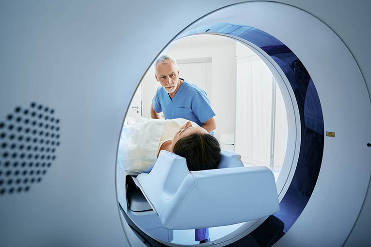 Mann der Patientin in den CT bringt