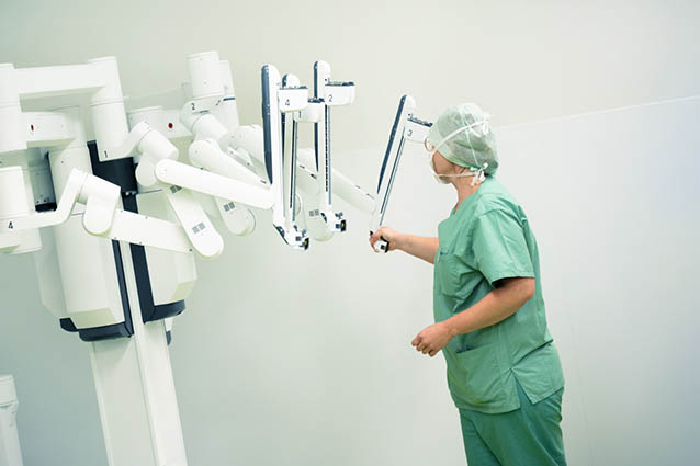 Mitarbeiterin mit dem DaVinci Operationsroboter