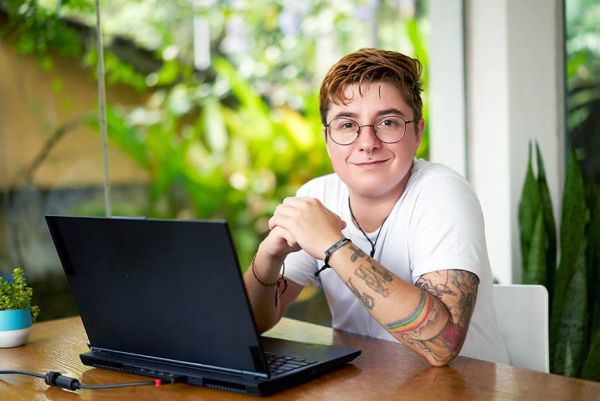 junger Trans Mann mit Laptop