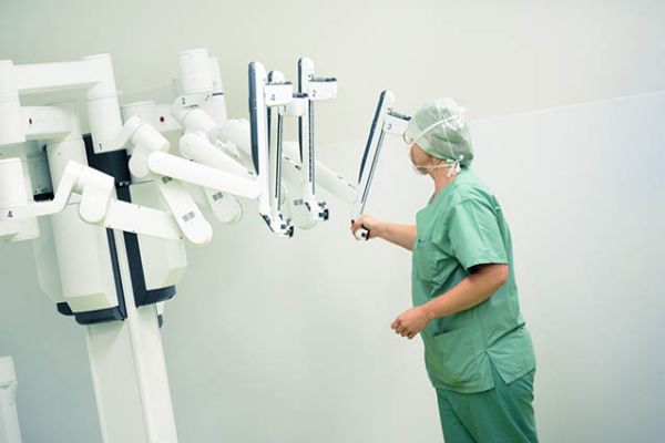 Mitarbeiterin mit dem DaVinci Operationsroboter