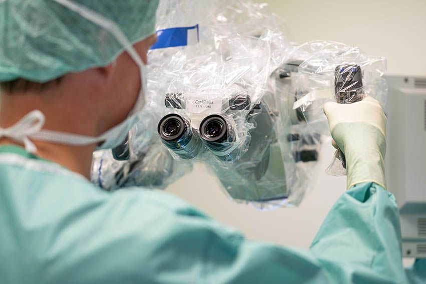 Dr Wallmichrath im OP mit einen OP Mikroskop
