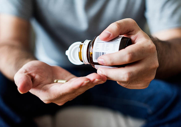 Männerhände mit Pillendose