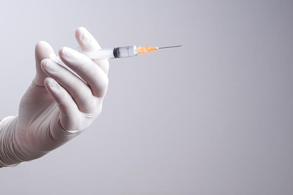 Hand hält Botox-Spritze